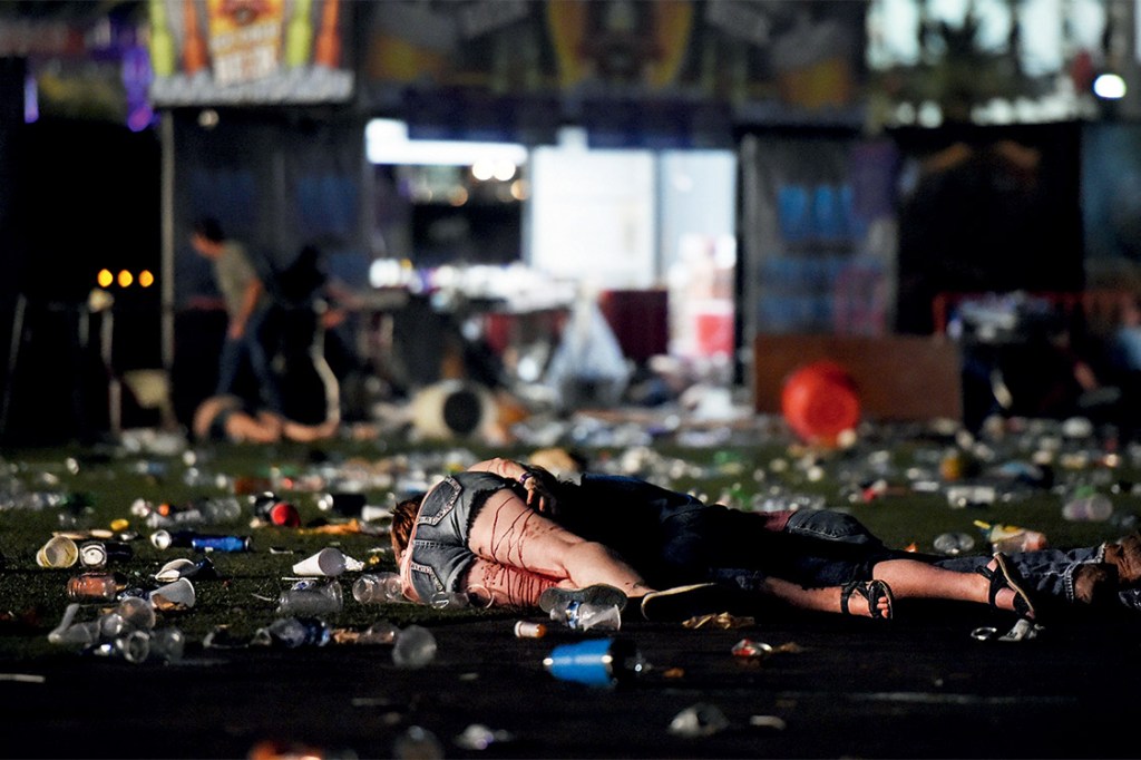 LAS VEGAS, NV - OCTOBER 01: (EDITORS NOTE: Image contains graphic content.) A person lies on the ground covered with blood at the Route 91 Harvest country music festival after apparent gun fire was heard on October 1, 2017 in Las Vegas, Nevada. There are reports of an active shooter around the Mandalay Bay Resort and Casino. David Becker/Getty Images/AFP