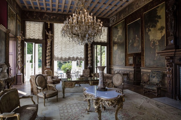 Poltronas, mesas, cadeiras e lustres combinam com os quadros na parede do século XIX para a decoração de uma sala de estar na mansão mais cara do mundo