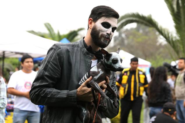 Homem segura cão durante desfile de Halloween para animais, em Lima, capital do Peru - 29/10/2017 Homem segura cão durante desfile de Halloween para animais, em Lima, capital do Peru - 29/10/2017