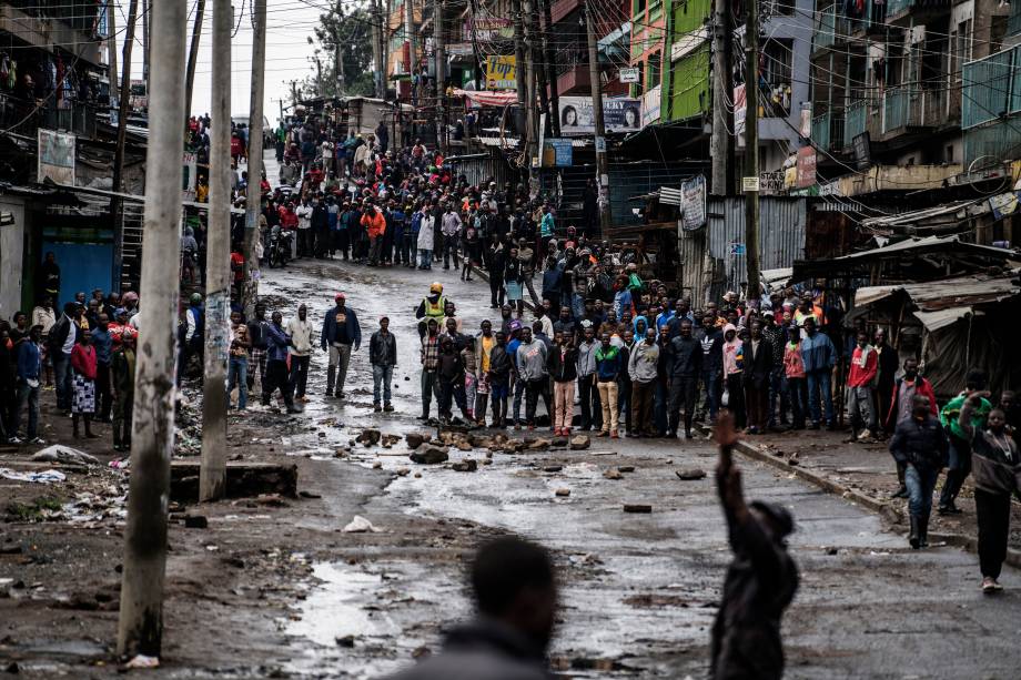 Moradores observam a ação de manifestantes que  tentam evitar que os eleitores acessem uma mesa de votação durante as eleições presidenciais em Mathare, Nairóbi - 26/10/2017