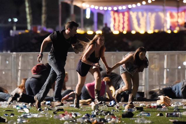 Pessoas correm ao ouvir tiros durante o festival 'Route 91 Harvest', em Las Vegas, no estado americano de Nevada. O atirador disparava do 32º andar de um prédio em frente ao espaço dos shows - 02/10/2017