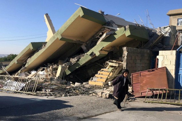 Homem atravessa um edifício danificado após um terremoto em Darbandikhan, na região de Sulaimaniya, no Iraque - 13/11/2017