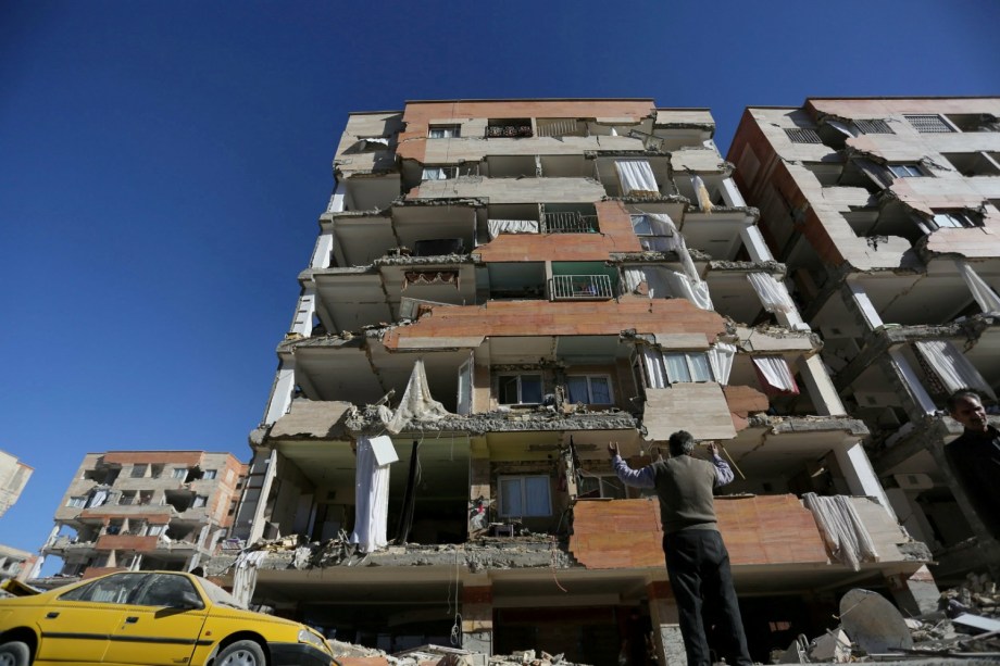 Homem reage ao olhar para um edifício danificado após um terremoto no condado de Sarpol-e Zahab, em Kermanshah, no Irã - 13/11/2017