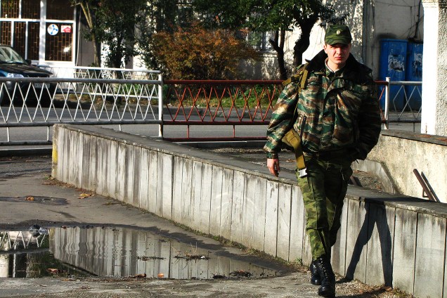 Militar caminha por rua nos arredores de Sukhumi.