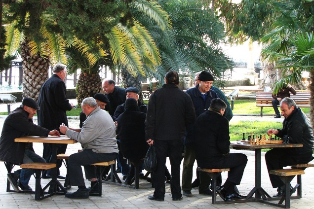 Homens jogam xadrez em praça pública de Sukhumi.