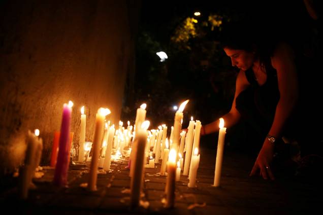 Mulher acende velas em frente ao Instituto Politécnico de Rosário, na Argentina, em memórias às vítimas do ataque em Nova York - 01/11/2017