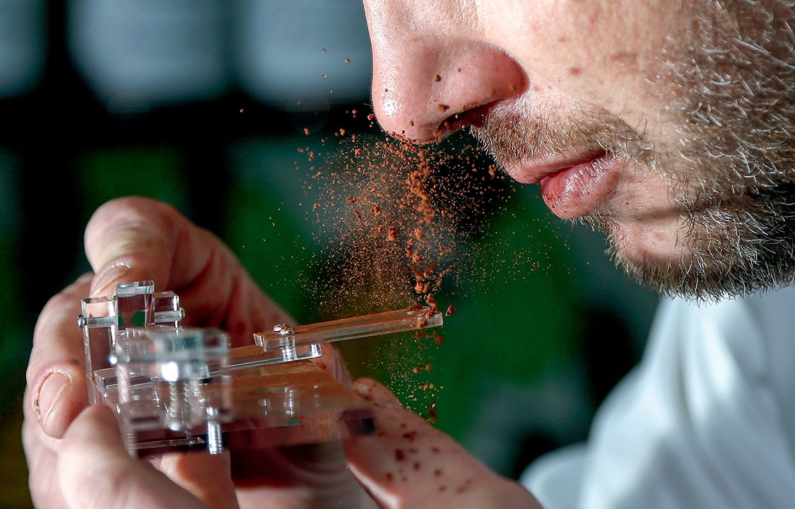 Belgian chocolatier Dominique Persoone snorts cocoa powder off his Chocolate Shooter in his factory in Bruges, February 3, 2015. When Belgian chocolatier Dominique Persoone created a chocolate-sniffing device for a Rolling Stones party in 2007, he never imagined demand would stretch much beyond the rock 'n' roll scene. But, seven years later, he has sold 25,000 of them. Inspired by a device his grandfather used to propel tobacco snuff up his nose, Persoone created a 'Chocolate Shooter' to deliver a hit of Dominican Republic or Peruvian cocoa powder, mixed with mint and either ginger or raspberry. Picture taken on February 3, 2015. REUTERS/Francois Lenoir (BELGIUM - Tags: FOOD SOCIETY) - GM1EB27012Y01