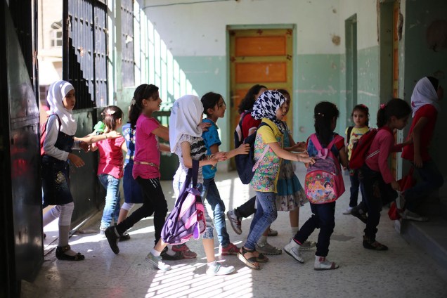 Crianças caminham juntas para a sala de aula em uma escola na cidade de Douma, controlada por rebeldes - 18/09/2017