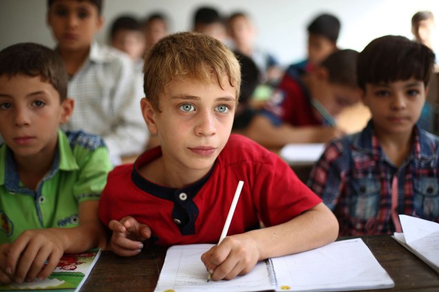Crianças sírias estudam em uma escola na cidade de Douma, controlada por rebeldes - 18/09/2017