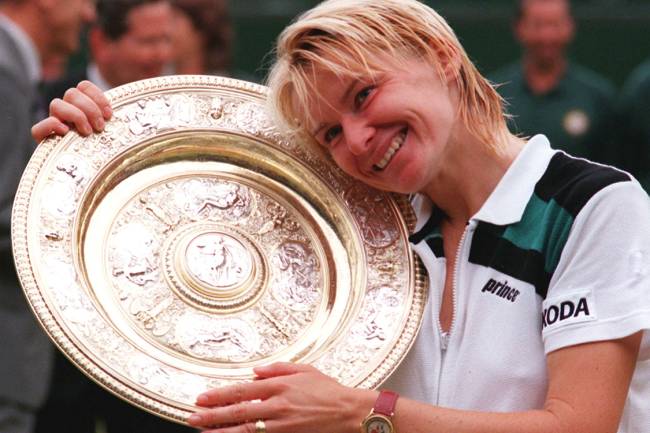 Tenista da República Tcheca, Jana Novotna, posa ao lado de seu troféu do torneio de Wimbledon, em 1998, após vencer partida contra a francesa Nathalie Tauziat