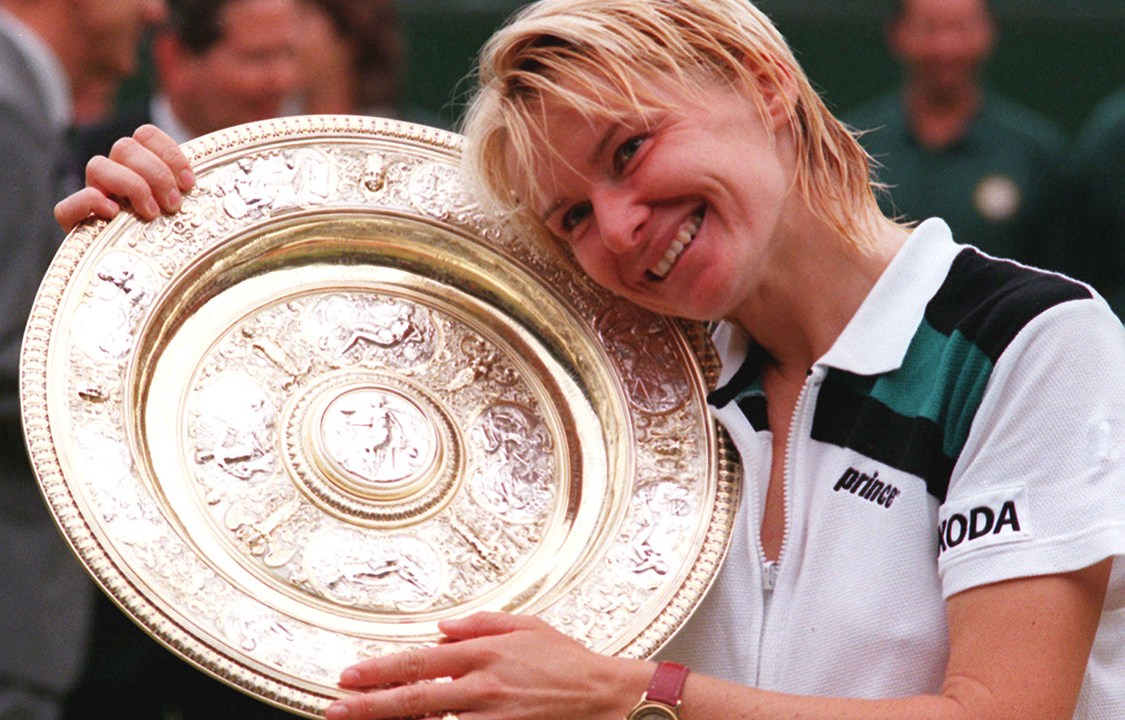 Tenista da República Tcheca, Jana Novotna, posa ao lado de seu troféu do torneio de Wimbledon, em 1998, após vencer partida contra a francesa Nathalie Tauziat