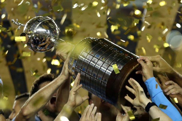 Jogadores do Grêmio levantam a taça da Libertadores após vencerem o Lanús, na Argentina