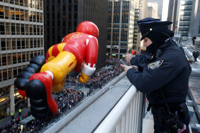 Policial do departamento de Nova York observa balão do personagem Ronald McDonald durante as preparações para o Dia de Ação de Graças em Manhattan, Nova York - 22/11/2017