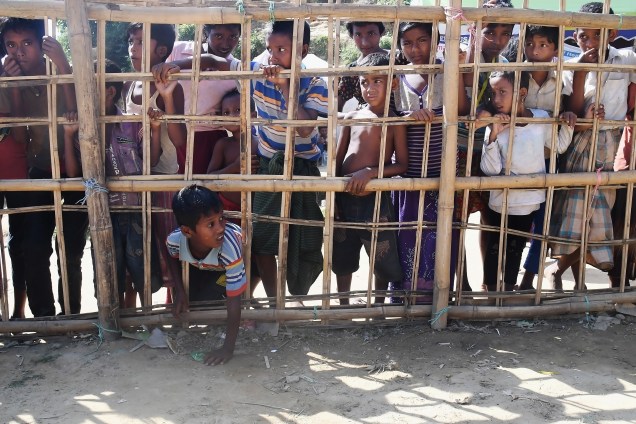 Jovens muçulmanos rohingyas ficam atrás de uma barricada de bambu para coletar comida cozida no campo de refugiados de Thankhali, no distrito de Ukhia, em Bangladesh - 10/11/2017