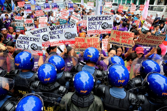 Policiais bloqueiam o grupo feminino 'Gabriela' durante um protesto na qual as mulheres denunciam a visita prevista do presidente dos Estados Unidos, Donald Trump, para participar da cúpula dos líderes da 31ª Associação das Nações do Sudeste Asiático (ASEAN) em frente da embaixada dos EUA, no metro Manila, nas Filipinas - 09/11/2017