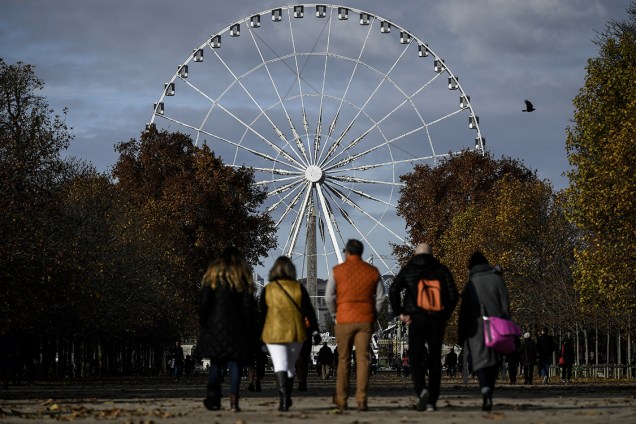 Turistas caminham pelo Jardim das Tulherias, em frente à "Grande Roue" em Paris, na França - 20/11/2017