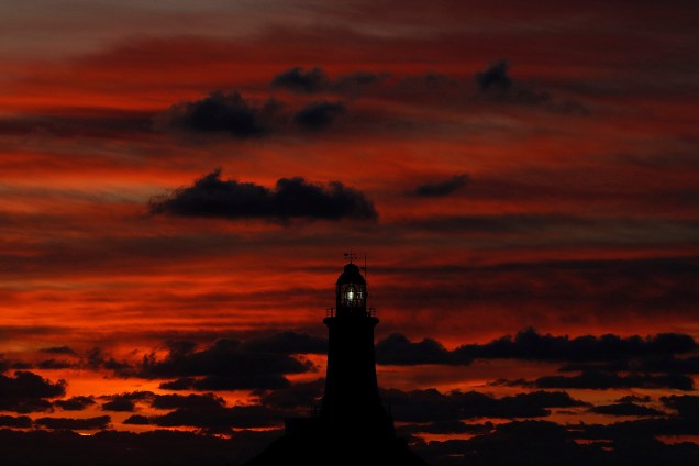 O farol da cidade de La Corbiere, na Ilha de Jersey, é fotografando durante o pôr do sol - 08/11/2017