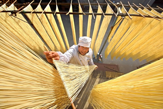 Aldeão trabalha coloca macarrão artesanal para secar em Linyi, na província de Shandong, na China - 21/11/2017