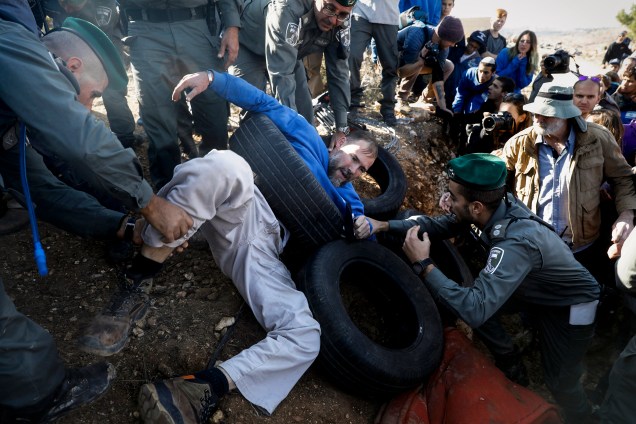Policiais israelenses evacuam colonos judeus que se escavaram dentro de uma estrutura construída ilegalmente em terras palestinas para evitar sua demolição, no assentamento judeu de Elazar ao sul de Belém, na Cisjordânia - 29/11/2017