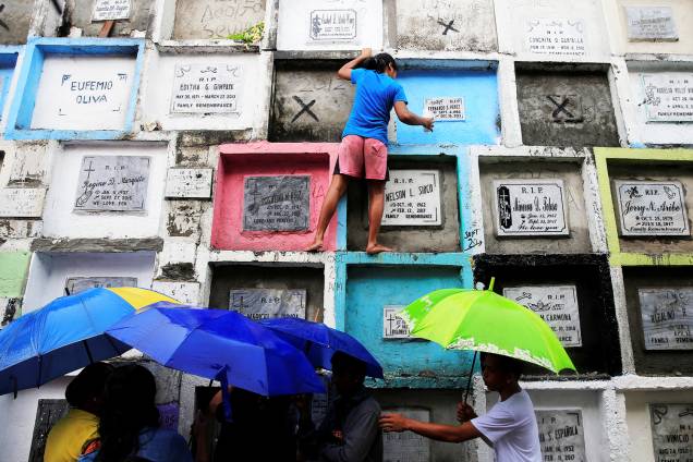 Pessoas visitam túmulos de seus entes queridos no Dia de Todos os Santos, em um cemitério público de Manila, nas Filipinas - 01/11/2017
