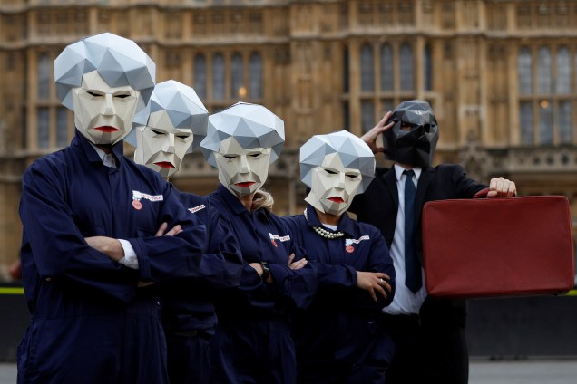 Grupo usa máscaras da primeira-Ministra Theresa May durante um protesto do lado de fora do Parlamento no dia em que o ministro das Finanças, Philip Hammond, apresenta seu orçamento em Londres - 22/11/2017
