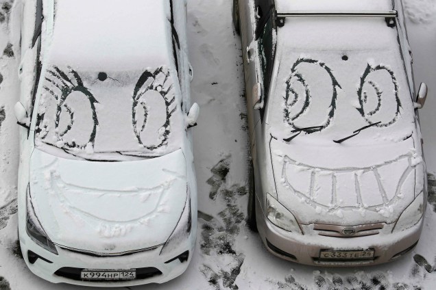 Após a neve cobrir os carros na cidade de Krasnoyarsk, na Rússia, pessoas desenham rostos sorridentes sobre os veículos - 08/11/2017