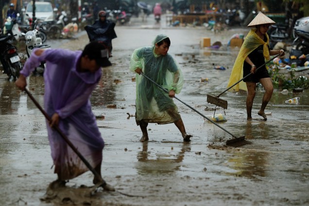 Pessoas limpam a lama das ruas após inundações causadas pela passagem do Furacão Damrey, na antiga cidade patrimonial da UNESCO, Hoi An, no Vietnã - 08/11/2017