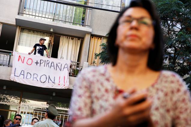 Manifestante com cartaz é visto na frente de escola pública onde o candidato Sebastian Pinera votou durante as eleições presidenciais - 19/11/2017 Manifestante com cartaz é visto na frente de escola pública onde o candidato Sebastian Pinera votou durante as eleições presidenciais - 19/11/2017
