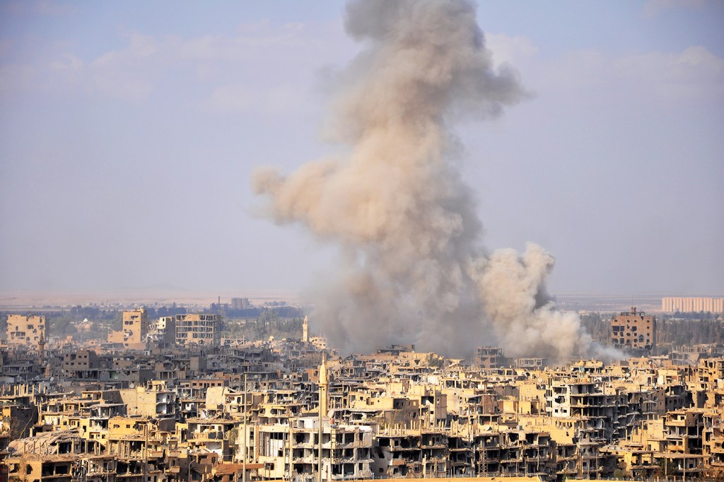 Fumaça é vista entre prédios durante ofensiva do Exército sírio para a retomada do território de Deir Ezzor - 02/11/2017