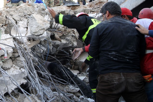Bombeiros trabalham nos escombros de prédio danificado em Sarpol-e Zahab, no Irã - 13/11/2017