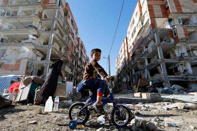 Garoto anda de bicicleta ao lado de prédios destruídos em Sarpol-e Zahab, após terremoto atingir a fronteira entre o Iraque e o Irã. 400 pessoas morreram - 14/11/2017 Garoto anda de bicicleta ao lado de prédios destruídos em Sarpol-e Zahab, após terremoto atingir a fronteira entre o Iraque e o Irã. 400 pessoas morreram - 14/11/2017