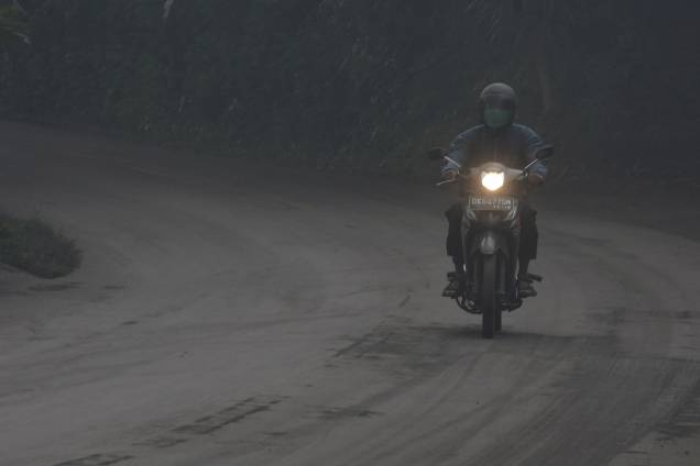 Motociclista atravessa uma estrada coberta de cinzas vulcânicas durante erupção do Monte Agung, em Bali, na Indonésia - 26/11/2017 Motociclista atravessa uma estrada coberta de cinzas vulcânicas durante erupção do Monte Agung, em Bali, na Indonésia - 26/11/2017