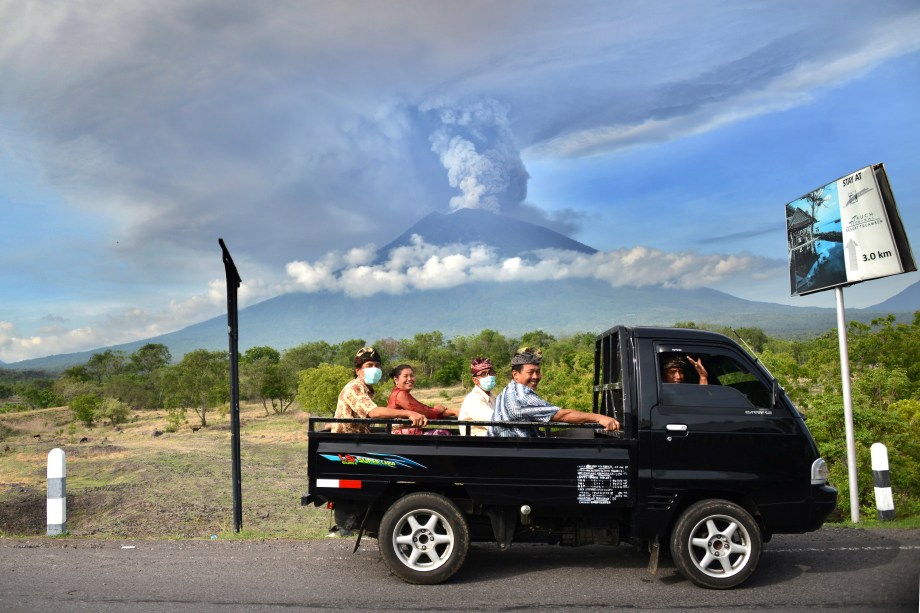 Balineses passam em frente ao Monte Agung durante uma erupção vista do subdistrito de Kubu em Karangasem Regency, na ilha turística de Bali, na Indoésia - 27/11/2017