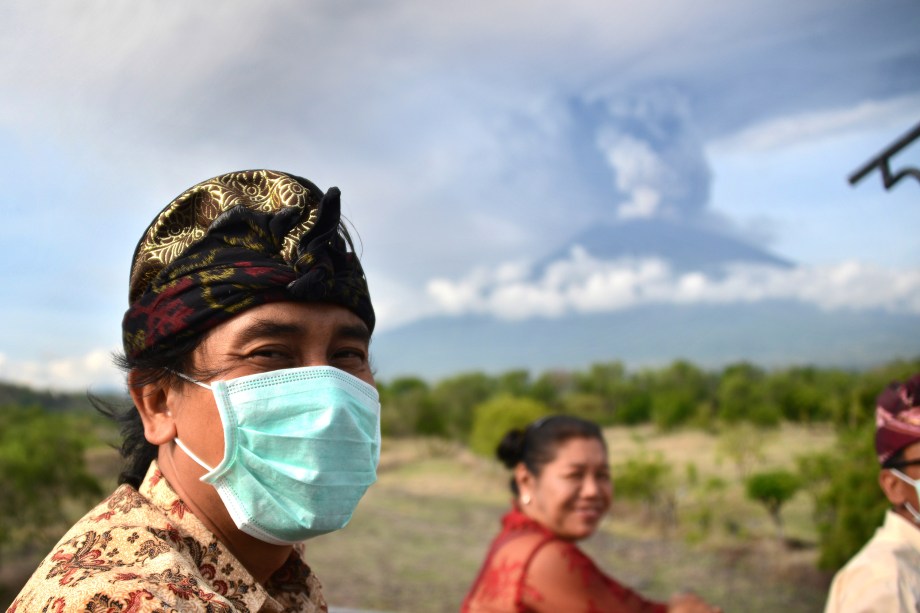 Balineses passam em frente ao Monte Agung durante uma erupção vista do subdistrito de Kubu em Karangasem Regency, na ilha turística de Bali, na Indoésia - 27/11/2017