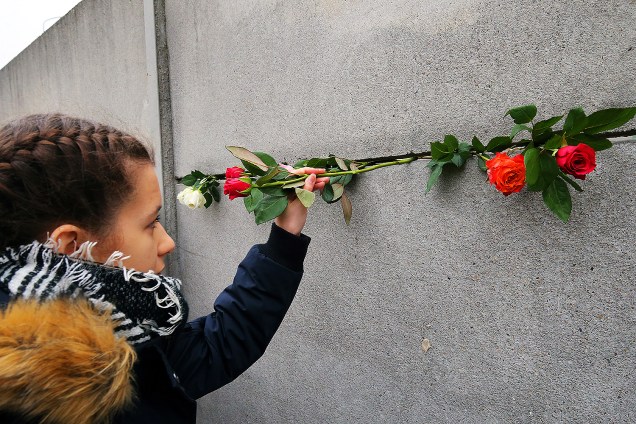 Jovem deixa flores em uma rachadura no Memorial para comemorar 28º aniversário da queda do Muro de Berlim - 09/11/2017