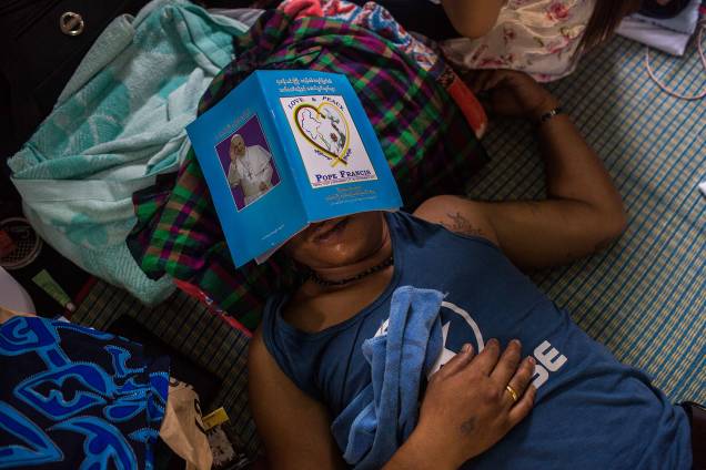 Um homem católico dorme com uma cópia do programa de visitação do papa Francis sobre os olhos na igreja de St. Anthony, no centro de Rangum, em Myanmar - 28/11/2017 Um homem católico dorme com uma cópia do programa de visitação do papa Francis sobre os olhos na igreja de St. Anthony, no centro de Rangum, em Myanmar - 28/11/2017