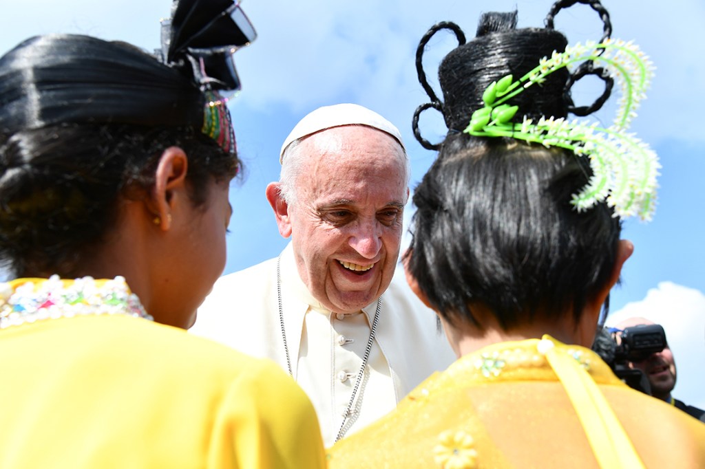 Papa Francisco cumprimenta crianças na saída do aeroporto em Mianmar.