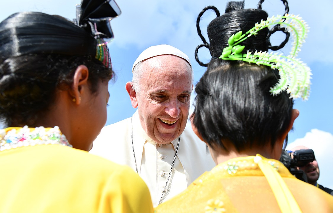 Papa Francisco cumprimenta crianças na saída do aeroporto em Mianmar.