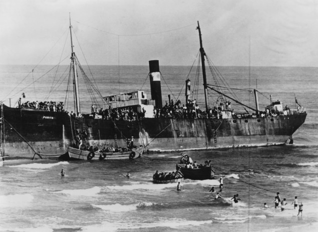 Com a ajuda das populações locais, cerca de 800 refugiados judeus começam a desembarcar do navio SS Parita, quando ele encalha no mar de Tel Aviv, na Palestina - 22/08/1939