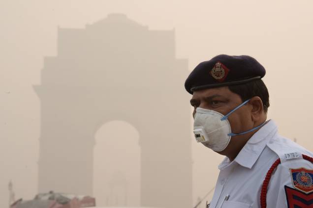 Policial indiano usa uma máscara de proteção enquanto trabalha perto do portão da Índia, em meio a poluição pesada em Nova Deli - 09/11/2017