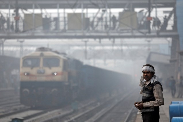 Homem é visto em meio a névoa da manhã na plataforma do trem em um estação de Nova Deli, na Índia - 10/11/2017