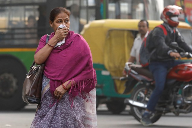 Mulher é vista cobrindo as vias aéreas com um lenço para se proteger da poluição em Nova Deli, capital da Índia - 14/11/2017