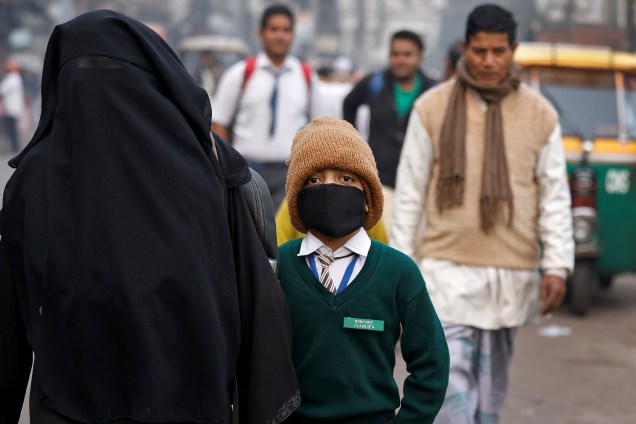 Um garoto é visto usando uma máscara para se proteger da poluição enquanto caminha para a escola em Nova Deli, na Índia - 15/11/2017