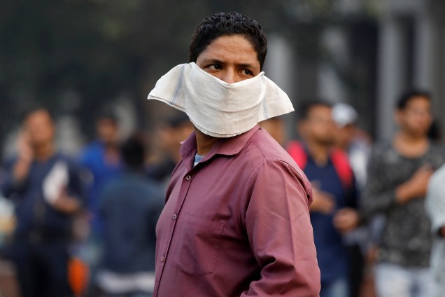 Um homem cobre o rosto com um lenço para evitar o ar poluído de Nova Deli, na Índia - 15/11/2017