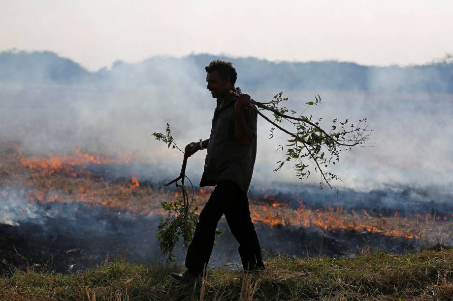 Um fazendeiro queima resíduos de arroz em um campo nos arredores de Ahmedabad, na Índia - 15/11/2017 Um fazendeiro queima resíduos de arroz em um campo nos arredores de Ahmedabad, na Índia - 15/11/2017
