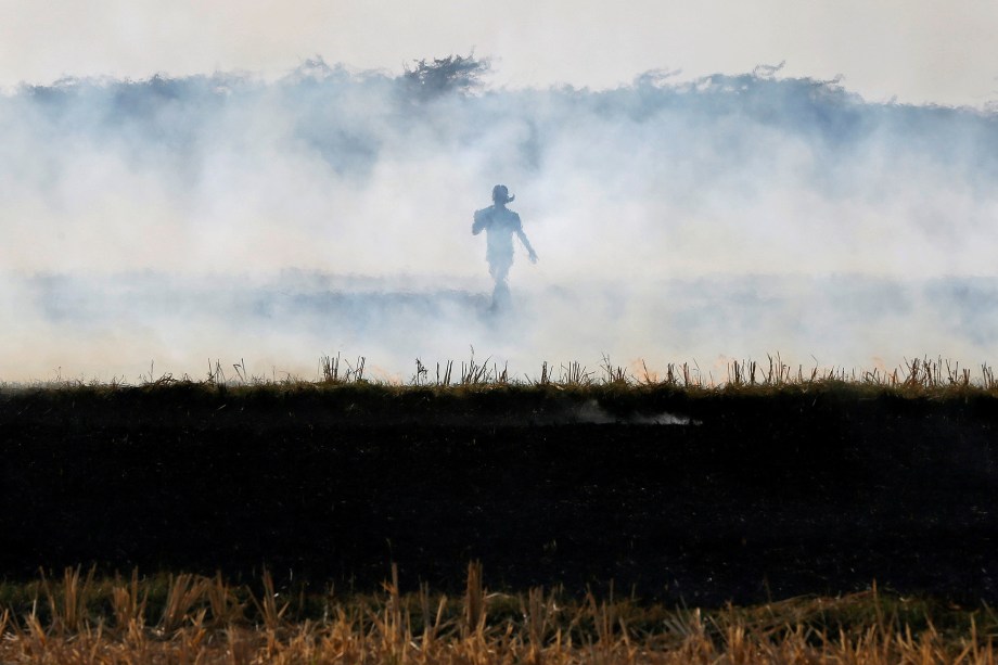 Um fazendeiro queima resíduos de arroz em um campo nos arredores de Ahmedabad, na Índia - 15/11/2017