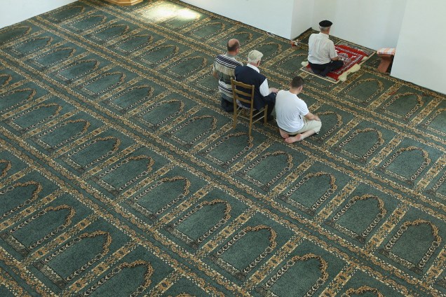 Quatro homens muçulmanos rezam em uma mesquita reconstruída com financiamento do Irã na região da Republika Srpska.