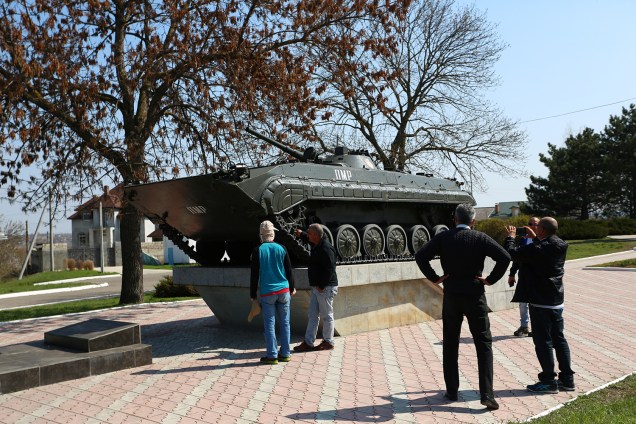 Pessoas tiram foto em frente a um blindado soviético em Tiraspol, na Transnístria.