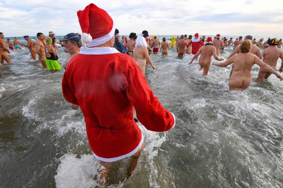 Pessoas participam de um banho de mar para marcar o final do ano na praia nudista de Cap d'Agde, no sul da França