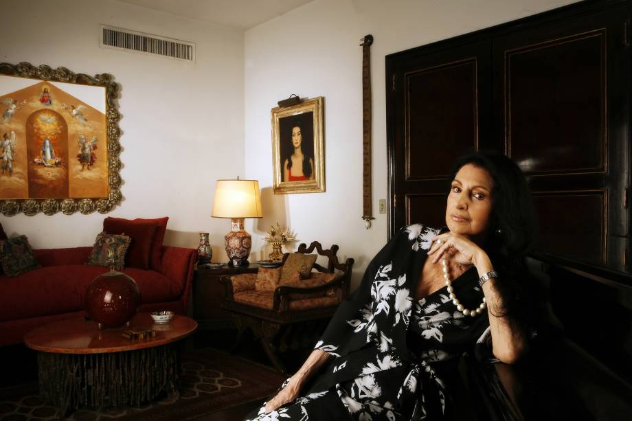 Socialite Carmem Mayrink Veiga, ao fundo seu retrato pintato por Candido Portinari